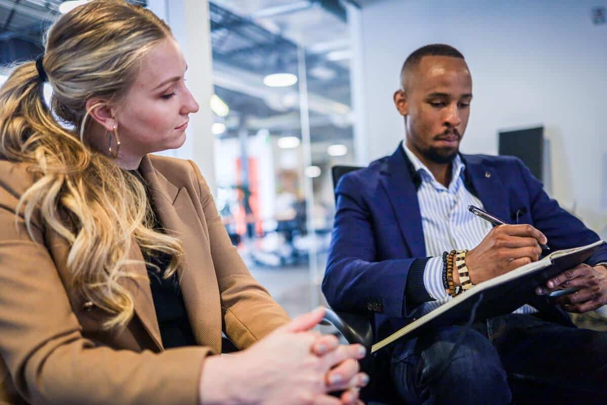 un homme écrit pendant que la femme regarde